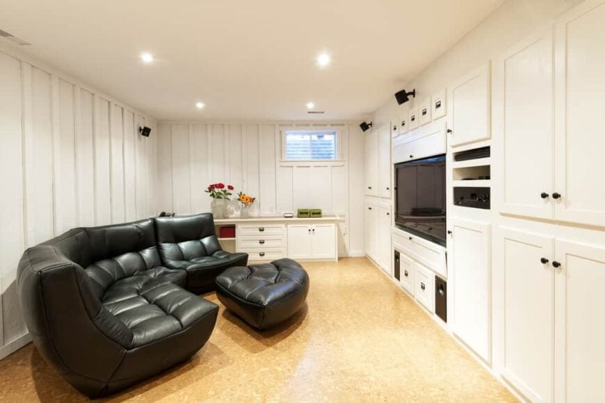 这是一个舒适舒适的地下室，白色墙壁和轻质硬木地板。