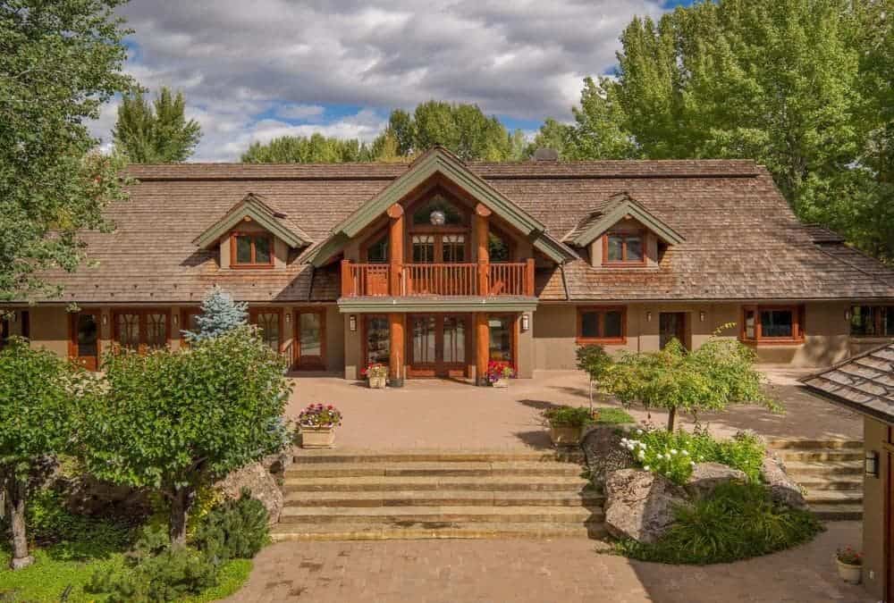 这座美丽的住宅被周围郁郁葱葱的绿色景观所包围，与房子的木质和泥土色调相得益彰。图片来自Toptenrealestatedeals.com。