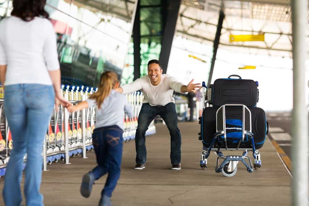 小女孩在机场奔向他父亲。