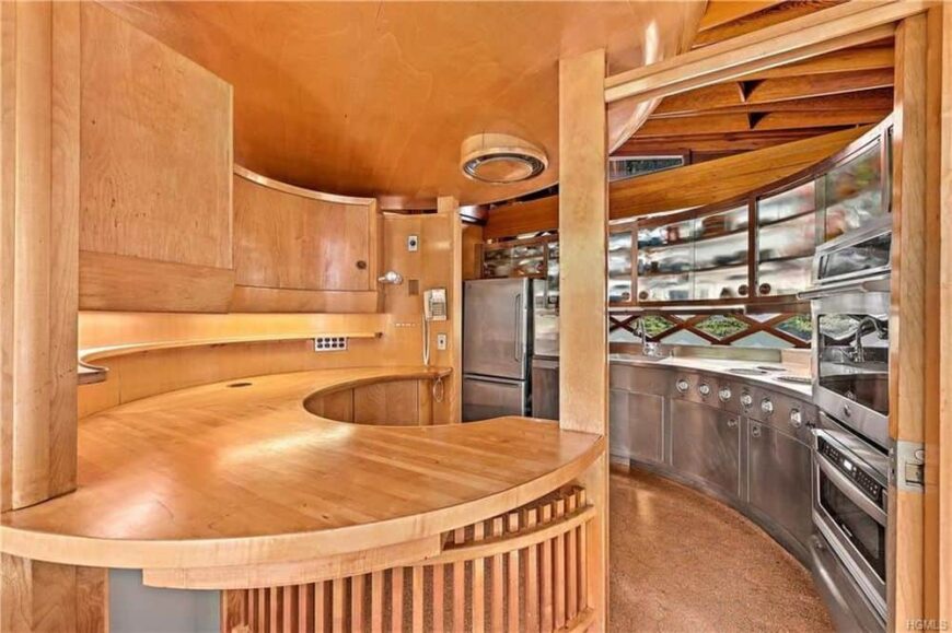 这是一个迷人的厨房，由天花板的木制元素、硬木地板和内置的木制弯曲计数木柱主导。