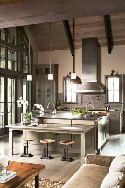 这个巨大的厨房设有一个大厨房岛，硬木地板上有一张内置桌子。这间厨房有高高的拱形天花板。
