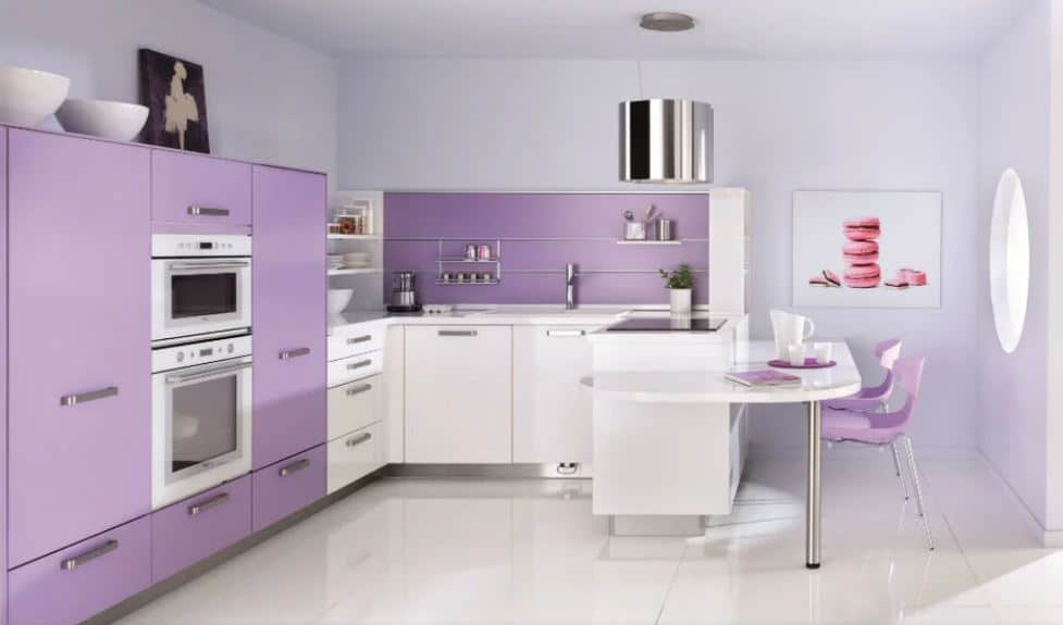 这间厨房以紫色抽屉和橱柜为特色。白色瓷砖地板上还有一张嵌壁式白色桌子。