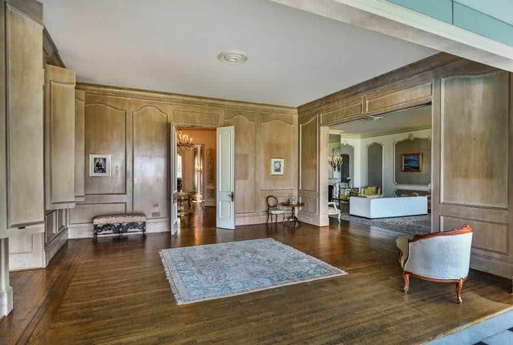 中央大厅设有木地板、地毯和舒适的沙发。它还有一个与木墙相匹配的木质橱柜。