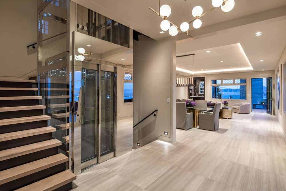 这个华丽的家的门厅和主厅设有自己的玻璃封闭电梯，由木制台阶的楼梯环绕。