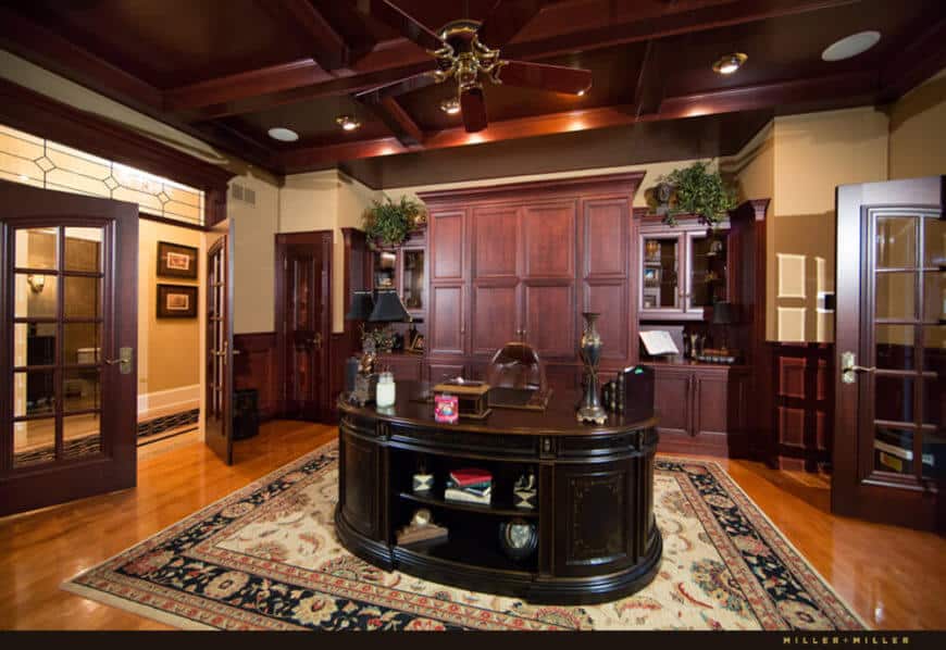 家庭办公室富丽堂皇，镶有厚木板，天花板镶有深格子，中央还有一张巨大的办公桌。两边都有入口，这是一个非常受欢迎的空间。