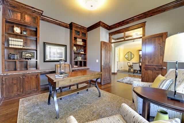 这个家庭办公室有一张经典地毯上的木桌和木制内置书架，与硬木地板相匹配。