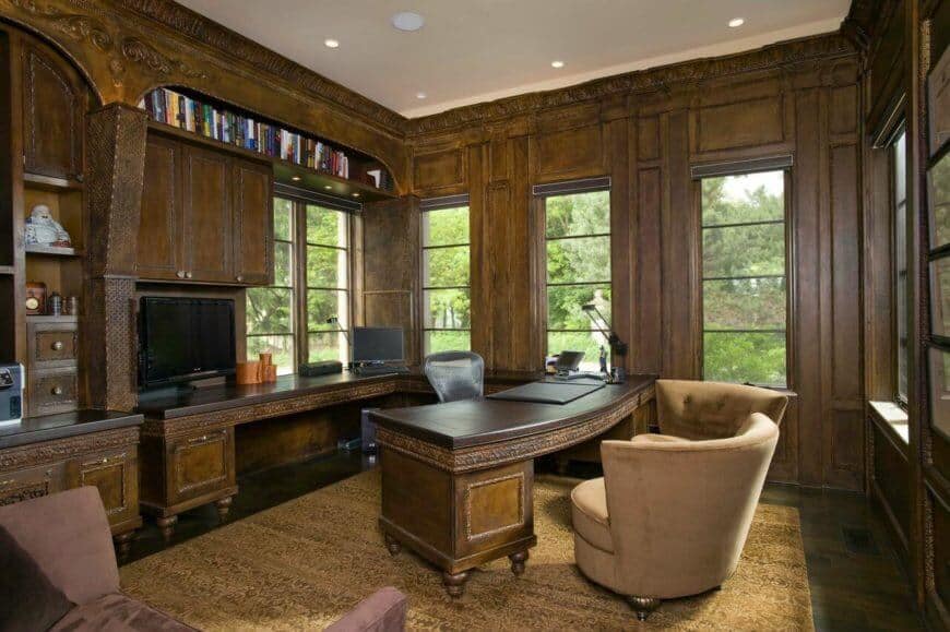 优雅的家庭办公室有可爱的皇冠造型，镶板和嵌入式办公桌。配套的弧形书桌从后墙延伸到房间的中心。