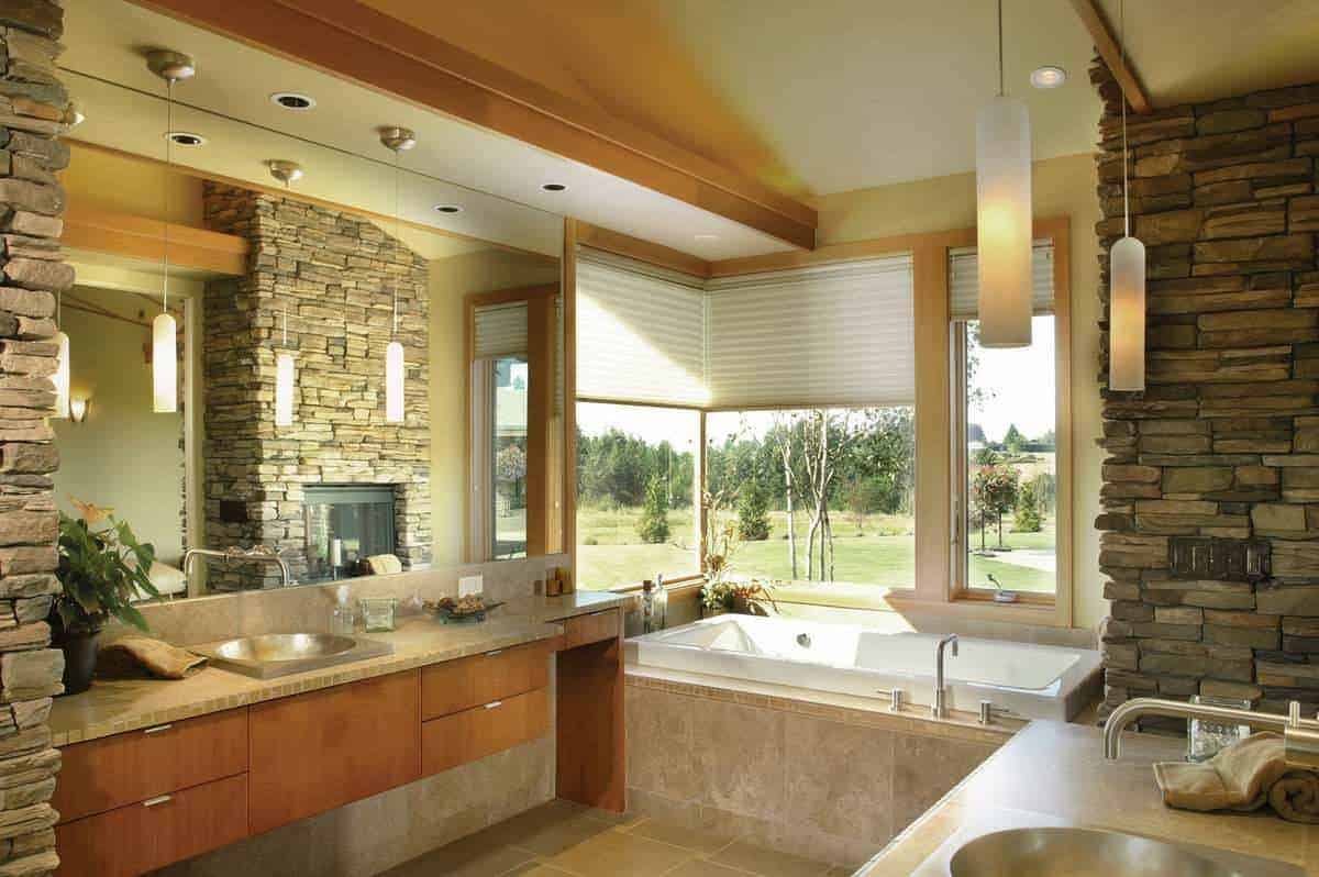 主浴室在窗户下提供了一个华丽的凹室浴缸，可以俯瞰美景。木制梳妆台和巨大的无框镜子。