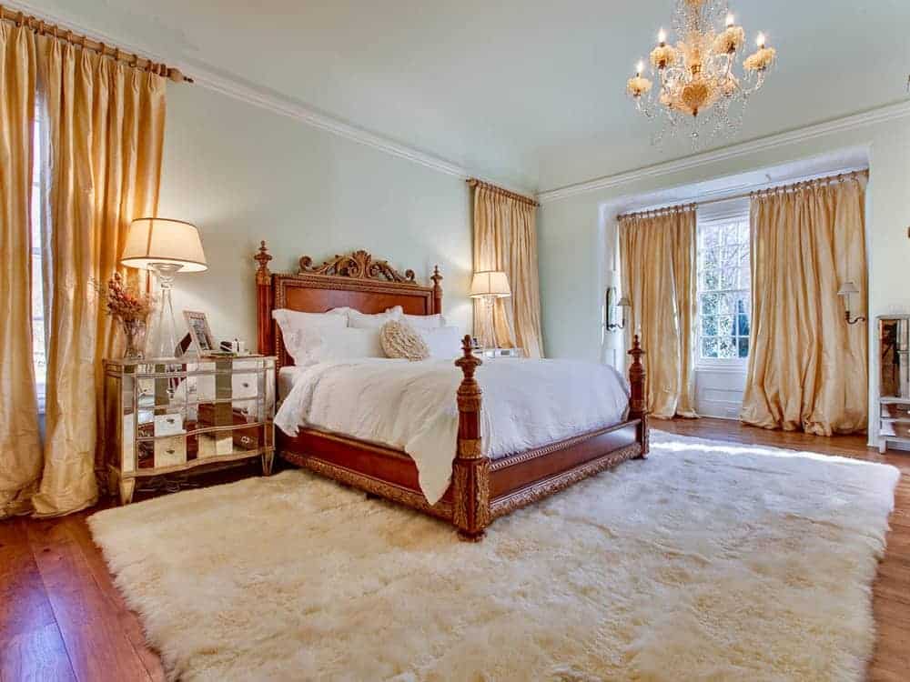 这间宽敞的主卧室有一张优雅的床，舒适的灯光由一个令人惊叹的蜡烛吊灯。