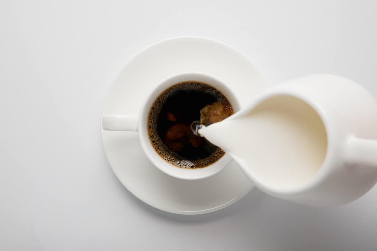 牛奶正倒在一杯咖啡里。