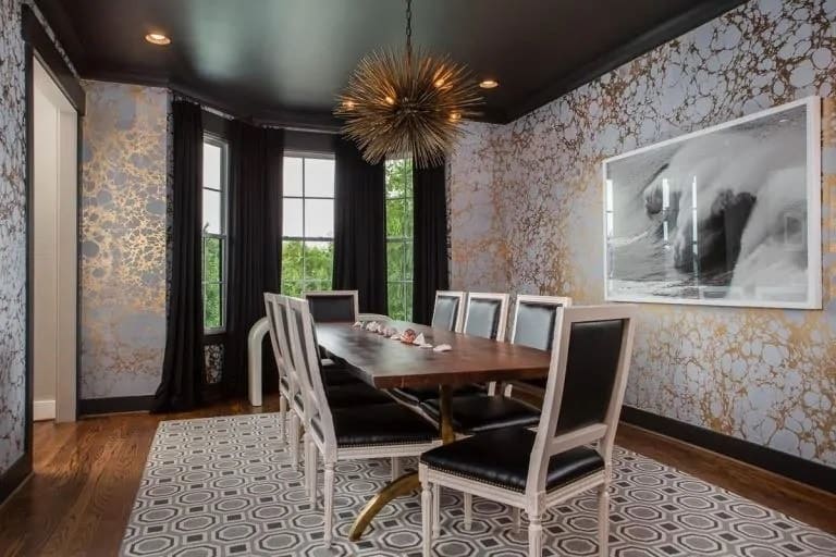 这个餐厅的美丽的白色花纹壁纸了独特的审美,对黑色的天花板,黑色的窗框和垫子的椅子周围的矩形的木制餐桌。这是进一步增强了装饰照明。