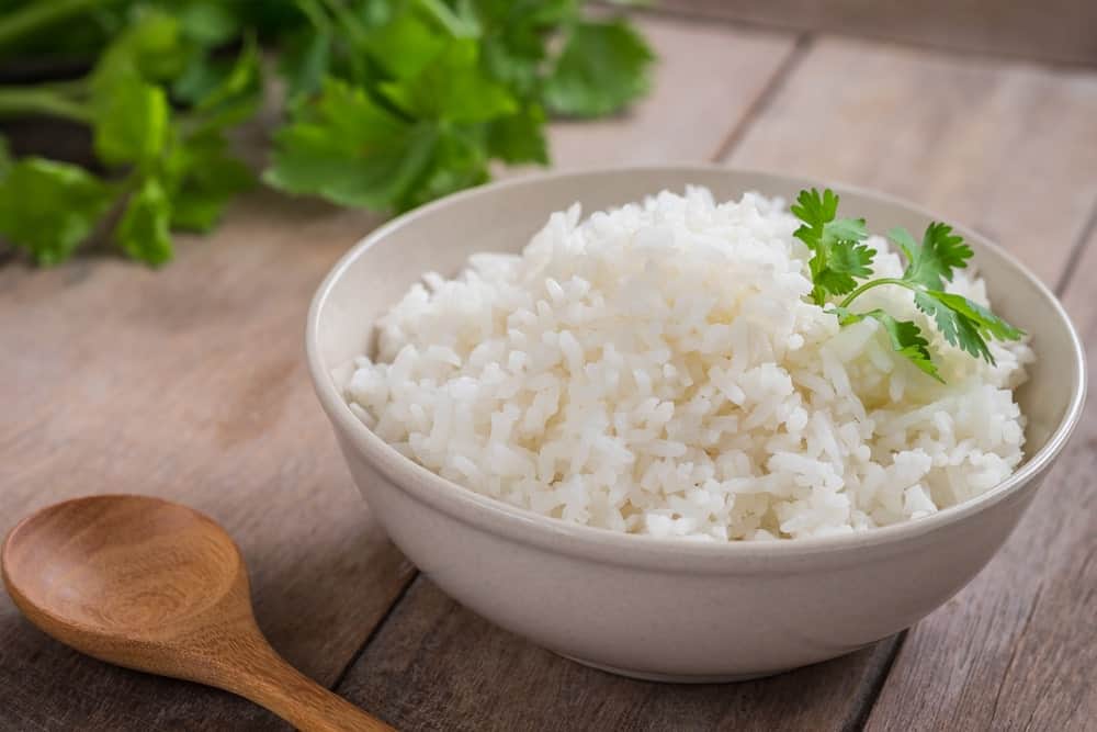 一碗漂亮的白米饭放在木制的表面上。