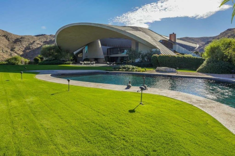 这是家里的室外游泳池，周围是保养良好的草坪。图片来自Toptenrealestatedeals.com。