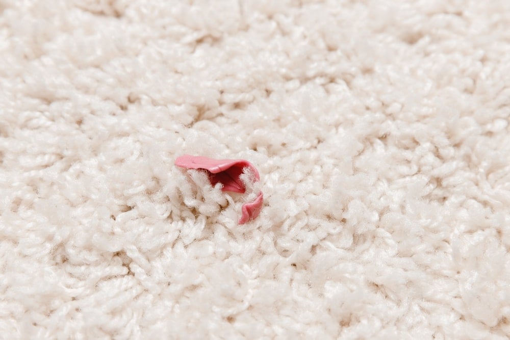 仔细观察粘在米色地毯上的口香糖。
