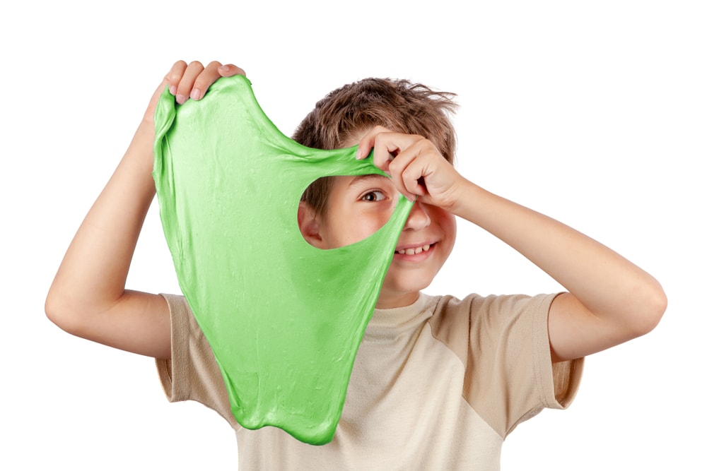 一个孩子玩一个大的绿色黏液。