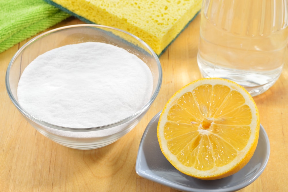 在清洁材料旁边放一片柠檬和一玻璃碗盐。