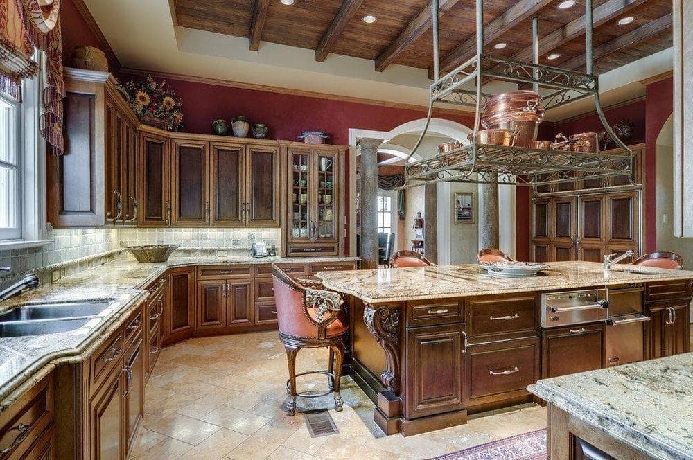 这个厨房的其他视图显示周围更多的橱柜,深棕色的颜色匹配和木托盘的天花板和厨房岛。图片由Toptenrealestatedeals.com。