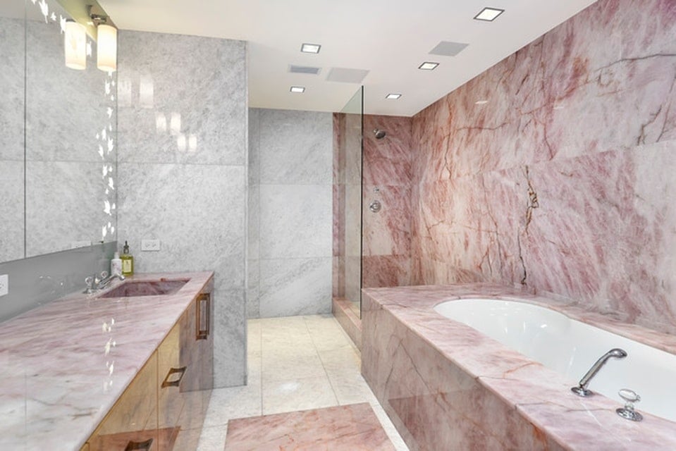 这个浴室在梳妆台对面有一个浴缸。墙壁和台面的玫瑰色大理石色调与之相辅相成。图片来自Toptenrealestatedeals.com。