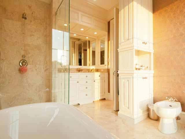 这是一个近距离观察的浴室，白色的瓷器浴缸，米色的墙壁和米色的橱柜与梳妆台相匹配。图片来自Toptenrealestatedeals.com。