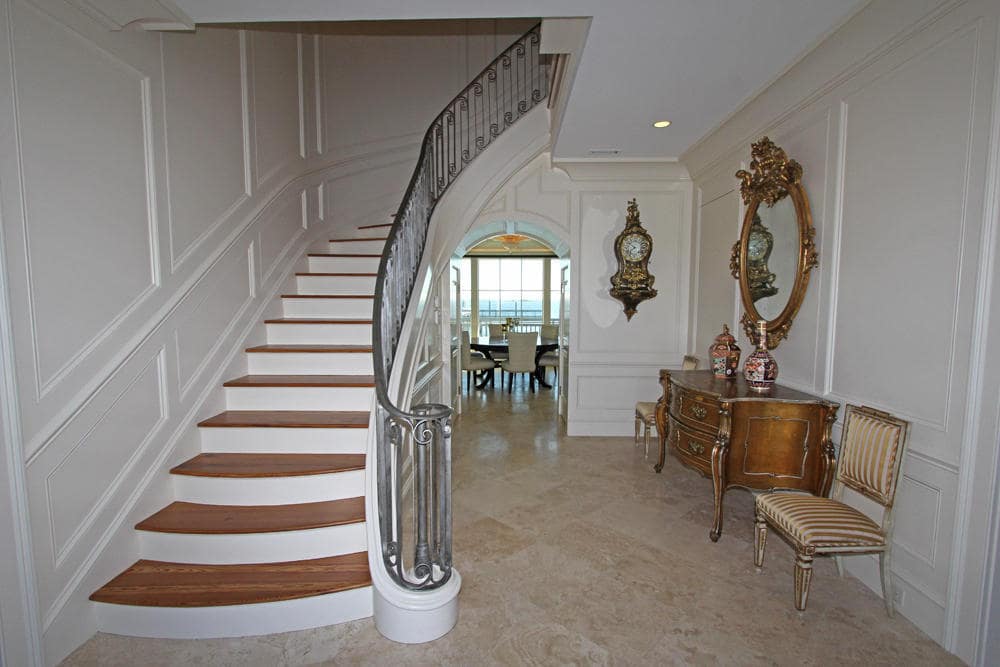 一进入房子，你就会受到这个宏伟的门厅的欢迎，门厅有一个弯曲的楼梯，侧面有一个顶部有镜子的控制台桌子。图片来自Toptenrealestatedeals.com。