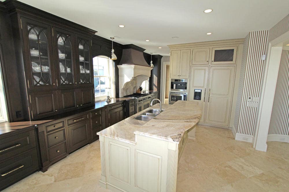 从厨房的另一个角度来看，厨房岛台远边缘的米色橱柜与米色色调相匹配。图片来自Toptenrealestatedeals.com。