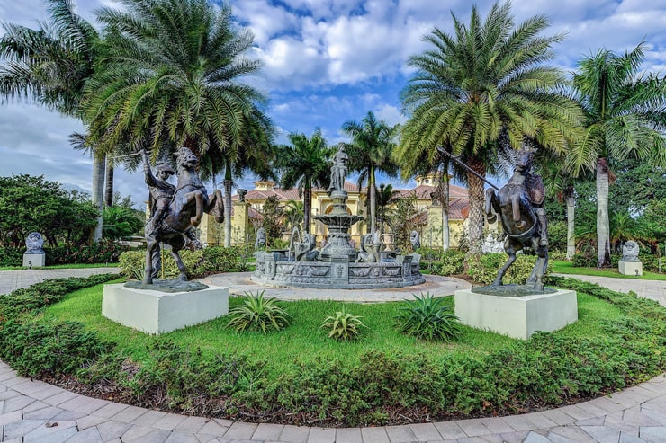 这是房子前面的大花园，有喷泉、热带树木、灌木和雕像。图片来自Toptenrealestatedeals.com。