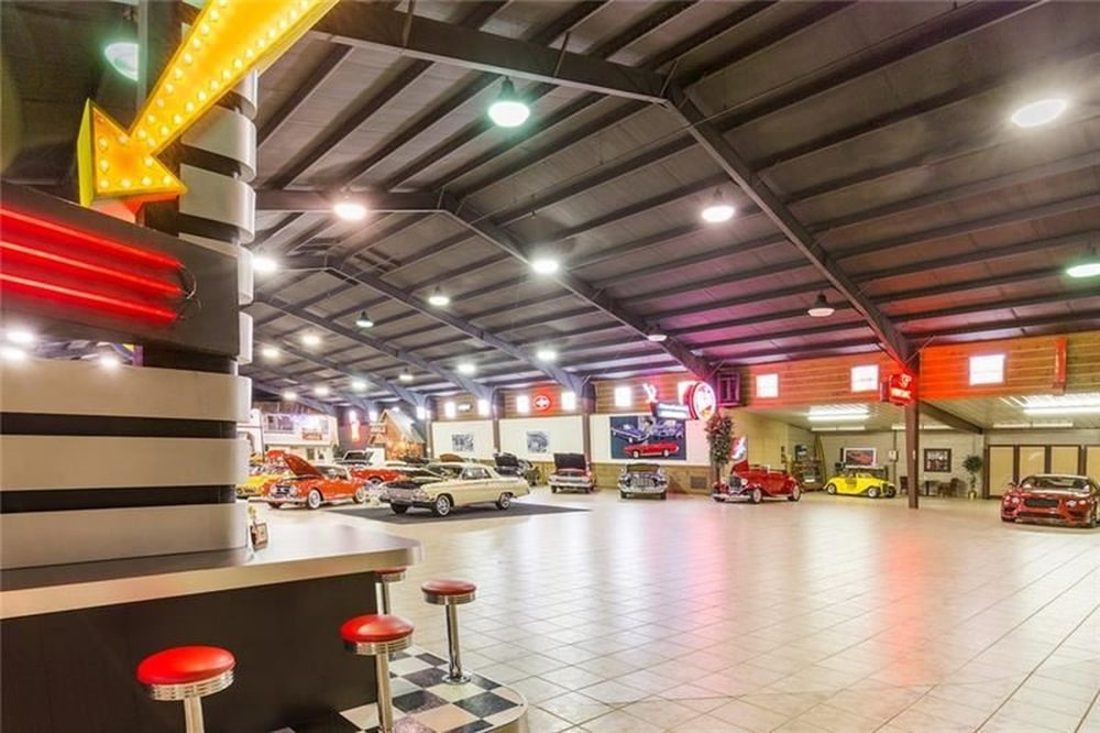 展厅的一侧是一个餐厅风格的酒吧，有固定的红色凳子和霓虹灯招牌。图片来自Toptenrealestatedeals.com。