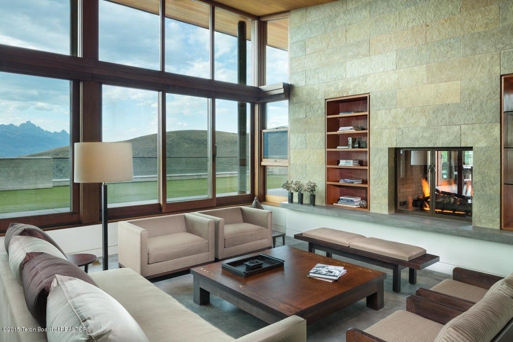这是客厅，有一面大玻璃墙，可以让自然光线进来。这与高耸的木质天花板相搭配。由Toptenrealestatedeals.com提供。