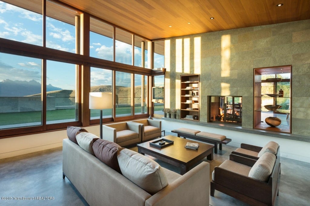 在客厅的另一幅图中，灰色沙发组与双向壁炉对面的木制咖啡桌搭配在一起。图片来自Toptenrealestatedeals.com。
