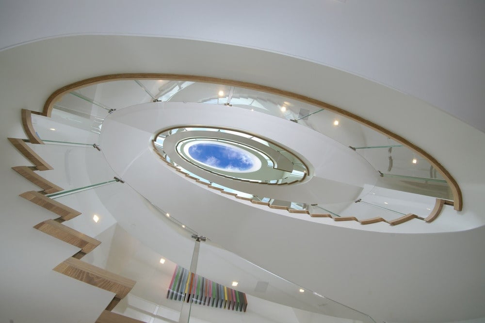 这是大厦的旋转楼梯，明亮的白色调和玻璃栏杆。图片来自Toptenrealestatedeals.com。
