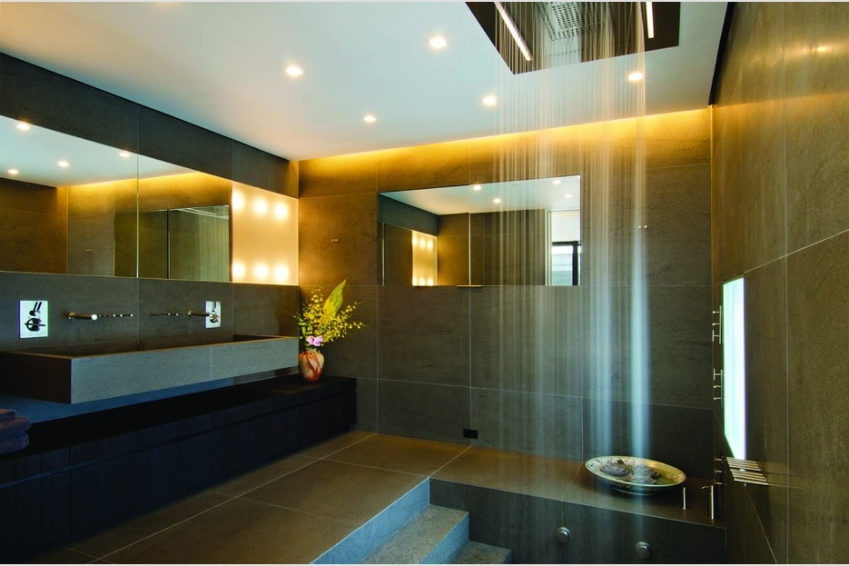 这间浴室的白色天花板与黑色墙壁和地板形成对比。这也显示了淋浴区和通往梳妆台的石阶。图片来自Toptenrealestatedeals.com。