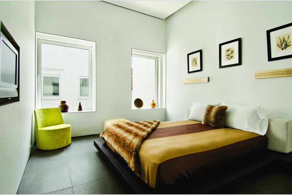这间卧室里有一张棕色床单的床，在白墙和黑地板的映衬下格外显眼。图片来自Toptenrealestatedeals.com。