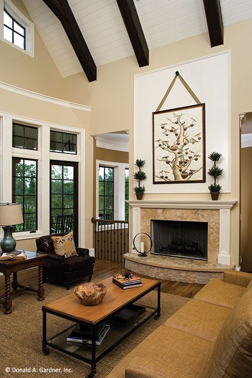 木质咖啡桌和一个大理石壁炉装饰通过盆栽和艺术品完成客厅。