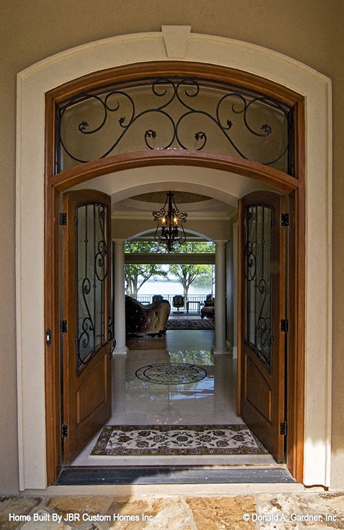 拱形法式门通往门厅，门厅铺着大理石地板，上面装饰着复杂的贴花图案。