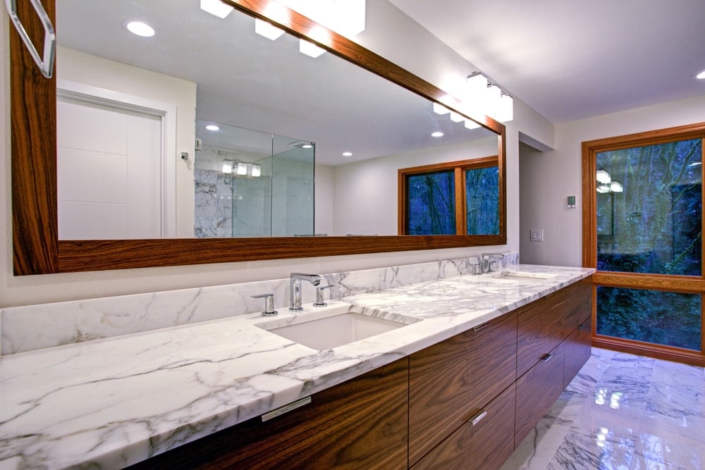 近距离观察浴室带有白色花岗岩台面的双水槽梳妆台。