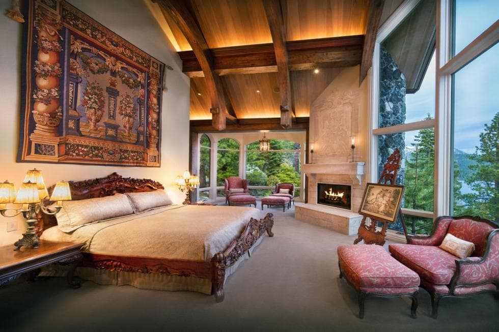 这个卧室有高大的木梁外露的拱形天花板。这是搭配了一个高大的墙壁装饰的彩色挂毯挂在大黑木头床。图片由Toptenrealestatedeals.com。