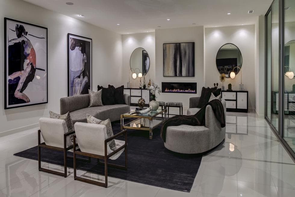 这是有纯白色墙壁、天花板和地板的客厅。这些使得灰色沙发套装与各种壁挂式艺术品和现代壁炉一起脱颖而出。图片来自Toptenrealestatedeals.com。