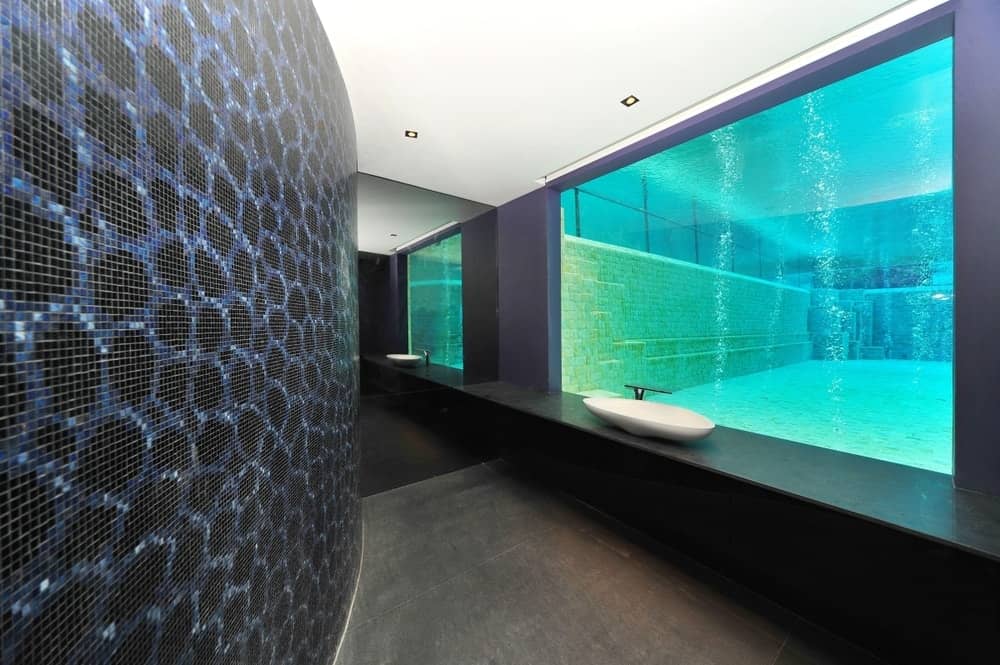 这是游泳池下面的地下室浴室，有玻璃墙，让游泳池呈现出水族馆般的美感。
