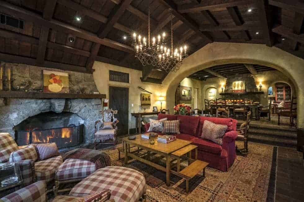 这个大房间的客厅区和餐厅区在远端。客厅里有一套彩色沙发，放在石头壁炉对面的木制咖啡桌两侧。图片来自Toptenrealestatedeals.com。