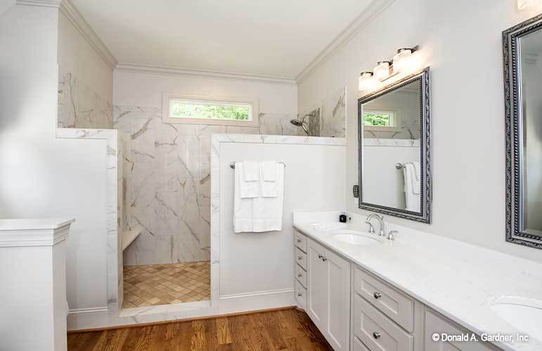 主浴室有一个淋浴区和一个配有装饰性镜子的双洗手池梳妆台。
