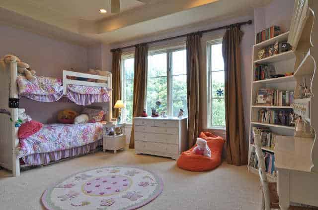 孩子们的卧室里有白色的家具，一张双层床，圆地毯，玻璃窗上挂着棕色的窗帘。