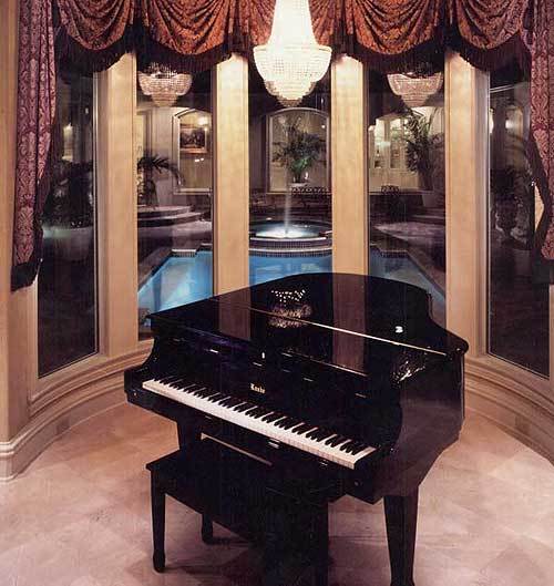 音乐室里有一架大钢琴、串珠吊灯和一扇俯瞰庭院游泳池的凸窗。