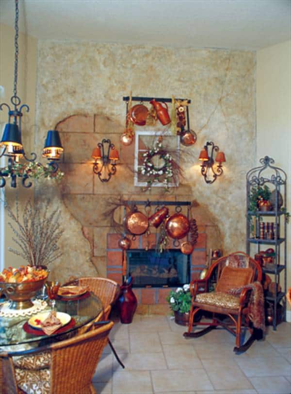 早餐角落圆形餐桌,柳条摇椅,铁艺架子单元,和一个玻璃幕墙壁炉。