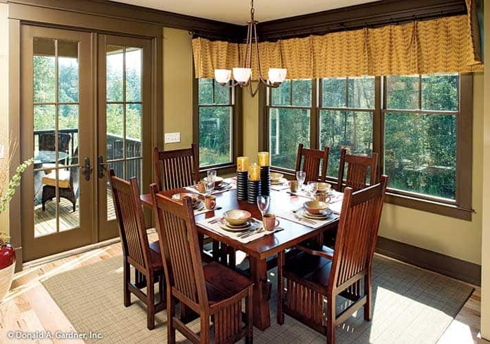 用餐区有一张木制餐桌，配套的椅子，方格地毯，和一个铜吊灯。
