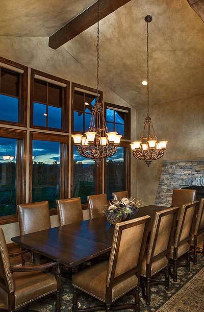用餐区有皮椅，深色木餐桌，和一对温暖的玻璃吊灯。