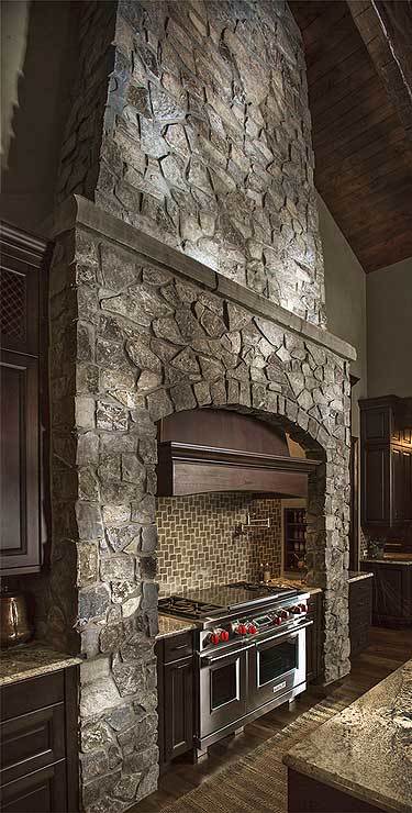 石头烹饪凹室，配有不锈钢炉灶和定制的通风罩。