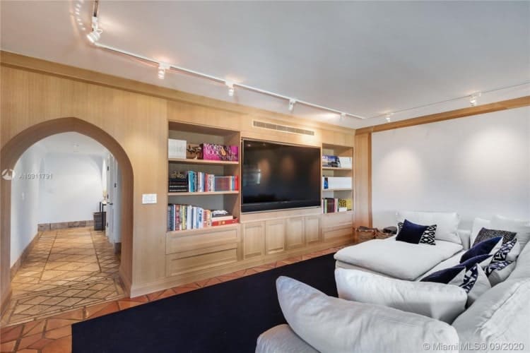 沙发上的白色基调匹配与补充的墙壁和天花板的木质结构电视。图片由Toptenrealestatedeals.com。