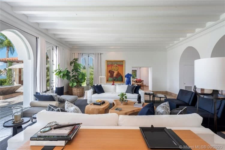 这是客厅,有沙发,咖啡桌辅以亮白色的墙壁和天花板和自然采光。图片由Toptenrealestatedeals.com。