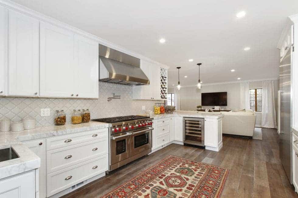 这是明亮的厨房,白色的橱柜,belnds墙壁和天花板。这些使不锈钢设备以及实木地板脱颖而出。图片由Toptenrealestatedeals.com。