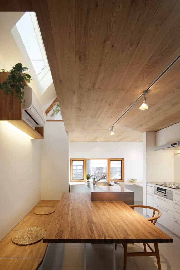 厨房的内置木凳上方是一个漂浮的木架子，上面放着分体式空调。
